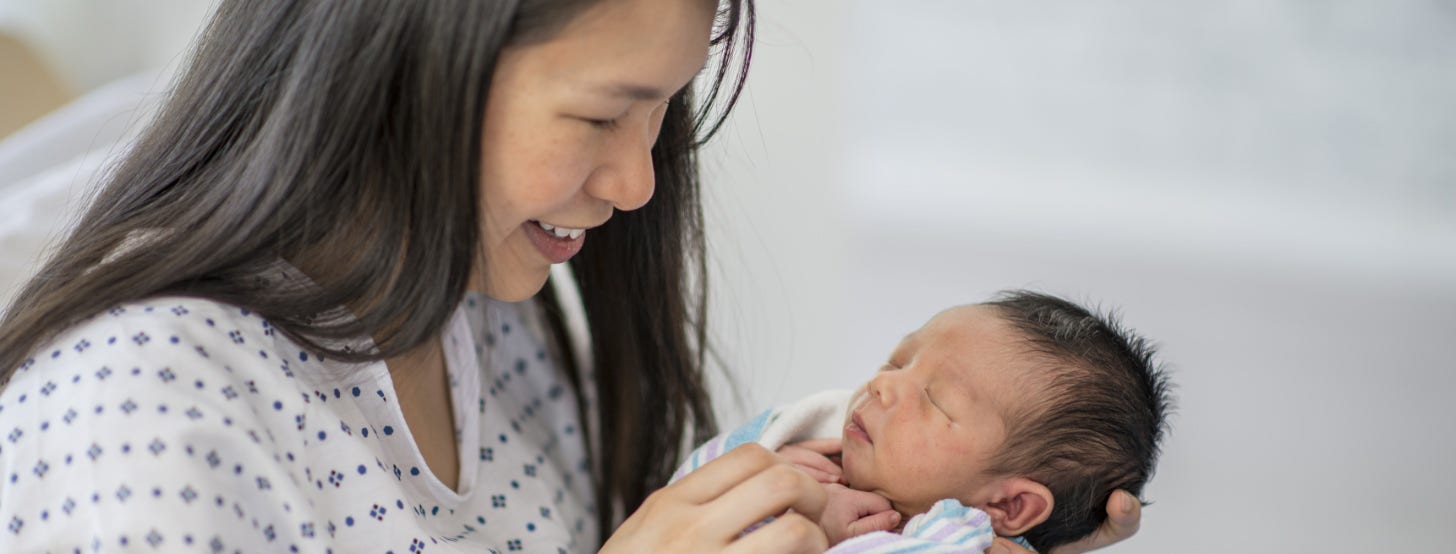 A woman holding her newborn baby.
