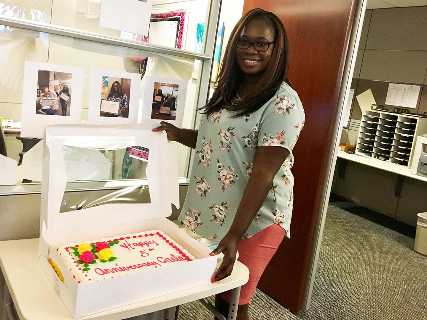 Carla is showing off a beautifully decorated cake in recognition of her 5th Amica anniversary.