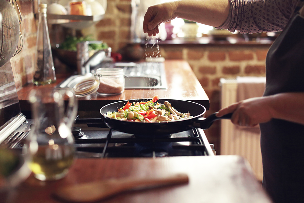 A pan full of vegetables being cooked on a stove top: Amica shares tips for National Burn Awareness Week