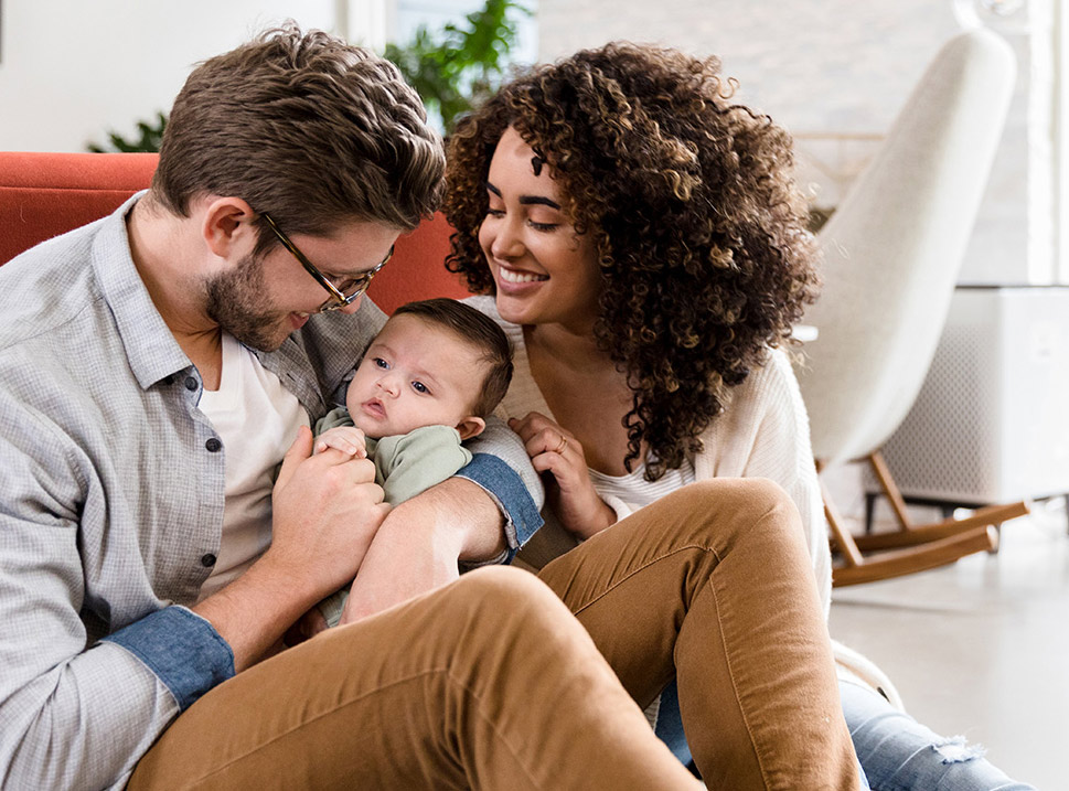 A family happily embraces with their baby.