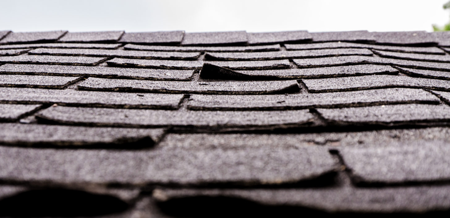 An old roof with lifting shingles.