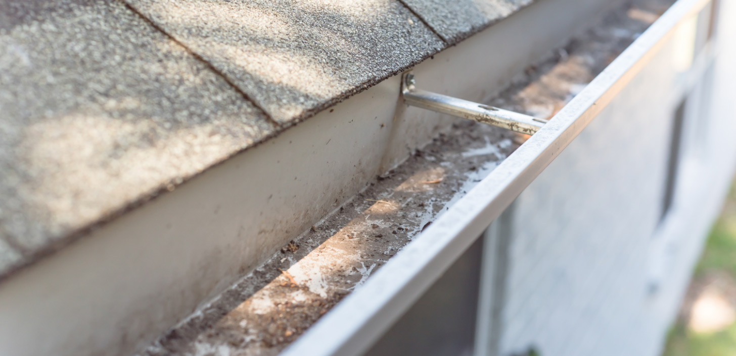 A roof with shingle granules in the gutters.